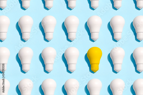 light bulb success business ideas creativity and inspiration concepts on blue background. Goal achievements flat lay minimalist composition