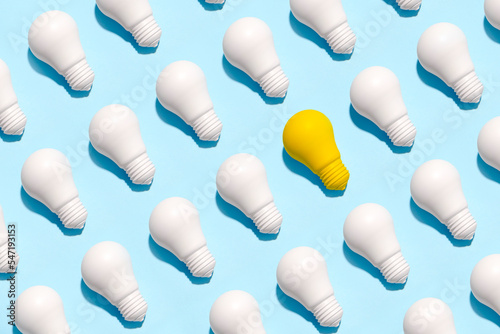 light bulb success business ideas creativity and inspiration concepts on blue background. Goal achievements flat lay minimalist composition