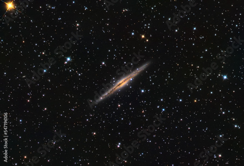NGC 891 galaxy in the Andromeda constellation, and some stars in the background.