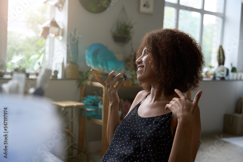 Joyful female florist making an audio clip at her workplace photo