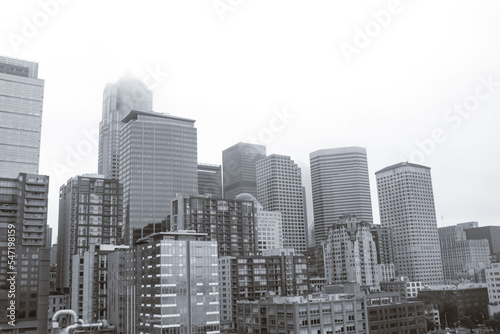 Seattle, Washington, USA- Downtown Seattle unidentifiable buildings skyline cityscape building viewed from waterfront on gloomy fog sky day in black and white
