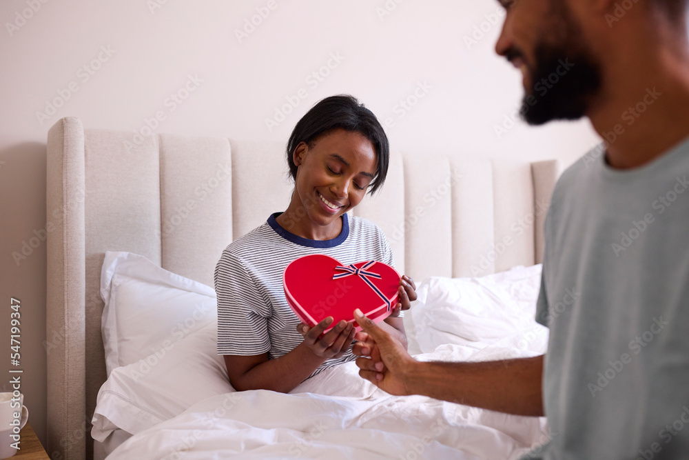 Loving Man Surprising Woman With Romantic Box Of Chocolates In Bedroom Loving Man Surprising Woman With Romantic Box Of Chocolates In Bedroom