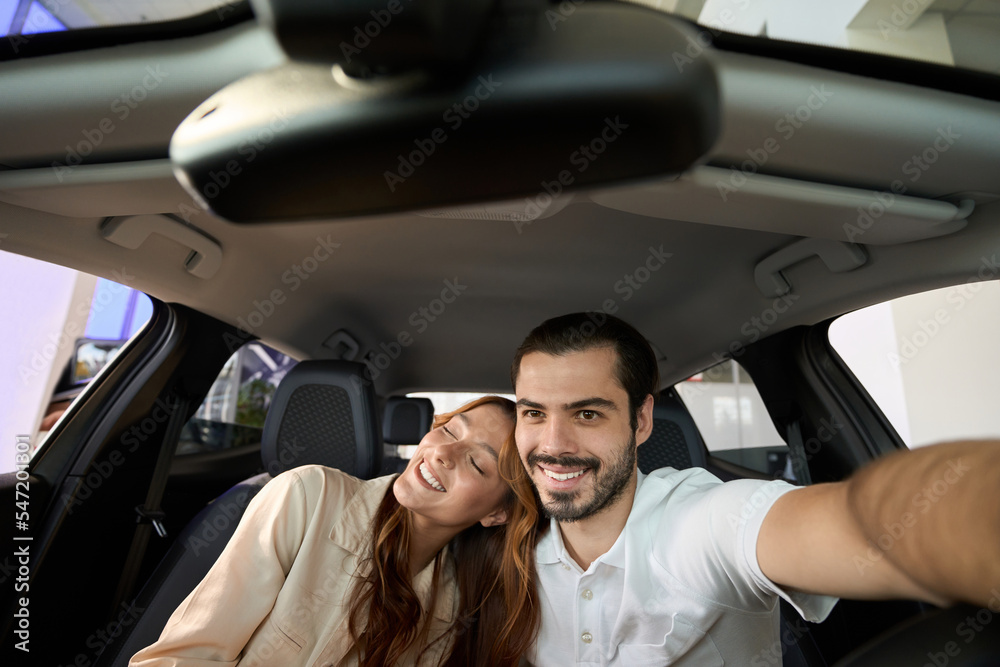 Romantic couple enjoying their new car purchase Romantic couple enjoying their new car purchase