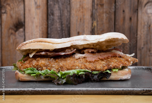 Gourmet sandwich. Closeup view of a multilayer sandwich with chicken fried steak, bacon, cheese and lettuce. 