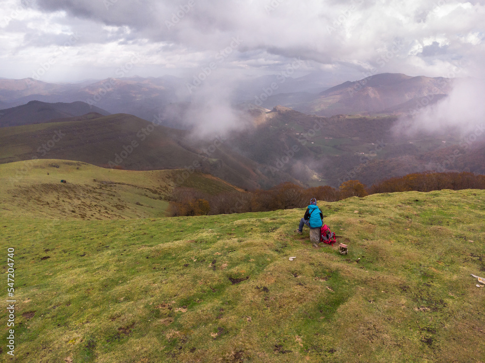 Hiker sitting on top of the mountain. Autumn in Belate