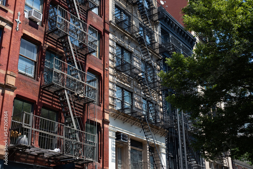 Row of Beautiful Old and Colorful Brick Apartment Buildings with Fire Escapes in SoHo of New York City © James