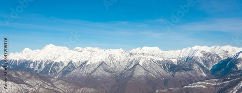 Wide panorama view of mountain peaks in winter season with clear cloudless weather. © aapsky
