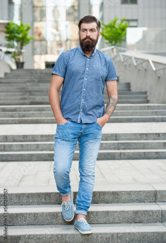 bearded guy walking downstairs. full length of guy with beard. caucasian guy outdoor