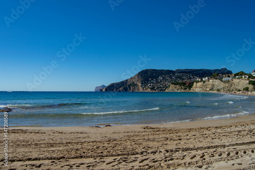 Playa de la costa blanca en el pueblo peque  o de Calpe en la provincia de Alicante con el mar Mediterr  neo bajo un precioso cielo soleado 