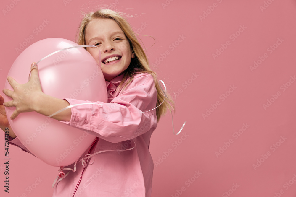 horizontal portrait of a cute, beautiful, happy girl with blond hair hugging a big balloon standing in a pink dress on a pink background with an empty space for an advertising tex horizontal portrait of a cute, beautiful, happy girl with blond hair hugging a big balloon standing in a pink dress on a pink background with an empty space for an advertising tex