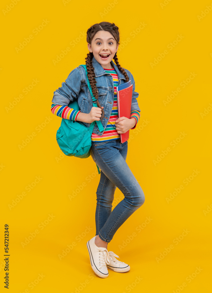 Surprised girl back to school. Teenage girl holding school books yellow background. School education Surprised girl back to school. Teenage girl holding school books yellow background. School education