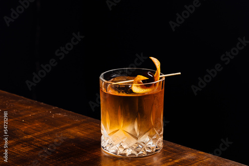 Bild auf Leinwand old fashioned cocktail on a wooden table and black background