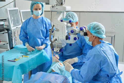 Bild auf Leinwand Close up photo of medical workers doing eye microsurgery