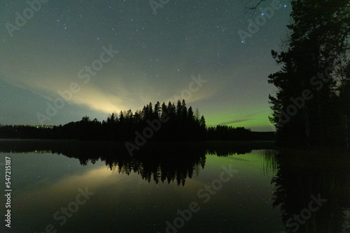 HInt of Aurora borealis in the horizon by the lake in Finland