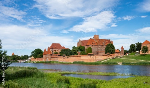 Landscape of Malbork castle with Nogat river and unrecognizable tourists