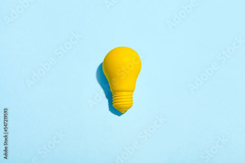 light bulb success business ideas creativity and inspiration concepts on blue background. Goal achievements flat lay minimalist composition