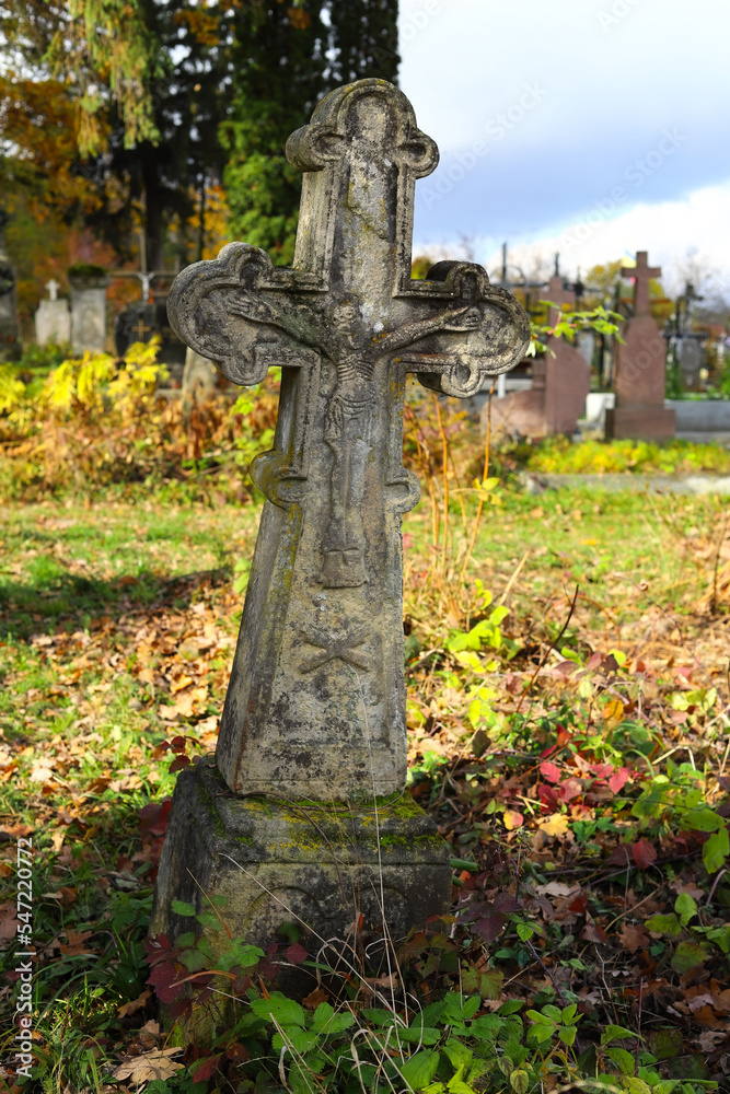 Old cemetery. Old neglected, mutilated figures of saints and crosses on graves. Remains of tombstones at a cemetery in Western Ukraine. Autumn sunny day. Old cemetery. Old neglected, mutilated figures of saints and crosses on graves. Remains of tombstones at a cemetery in Western Ukraine. Autumn sunny day.