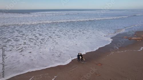 FRENCH DRONE France, aerial view of two people in vacation, ready for surf the wave. Relax scene of an alone sunset in Bidart