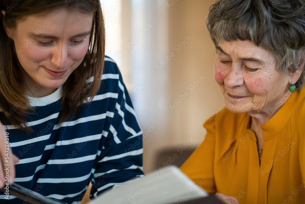Old woman with her granddaughter look at family photos. Old woman with her granddaughter look at family photos.