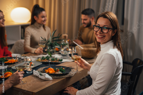 Woman looks at camera on dinner with friends