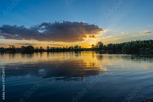 Beautiful  colorful sunset sunrise over a lake. Rays and clouds reflected in calm water  Slovakia  Europe