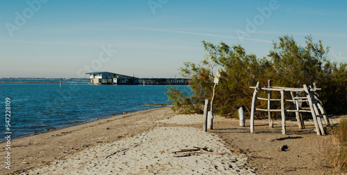 Marine background. Beach view with rustic wooden huts and small fish processing plant in the background. Rosolina, Italy photo