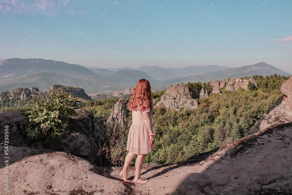 Woman wandering around at Belogradchik fortress. A beautiful fort with views over the nature with rocks and green. 