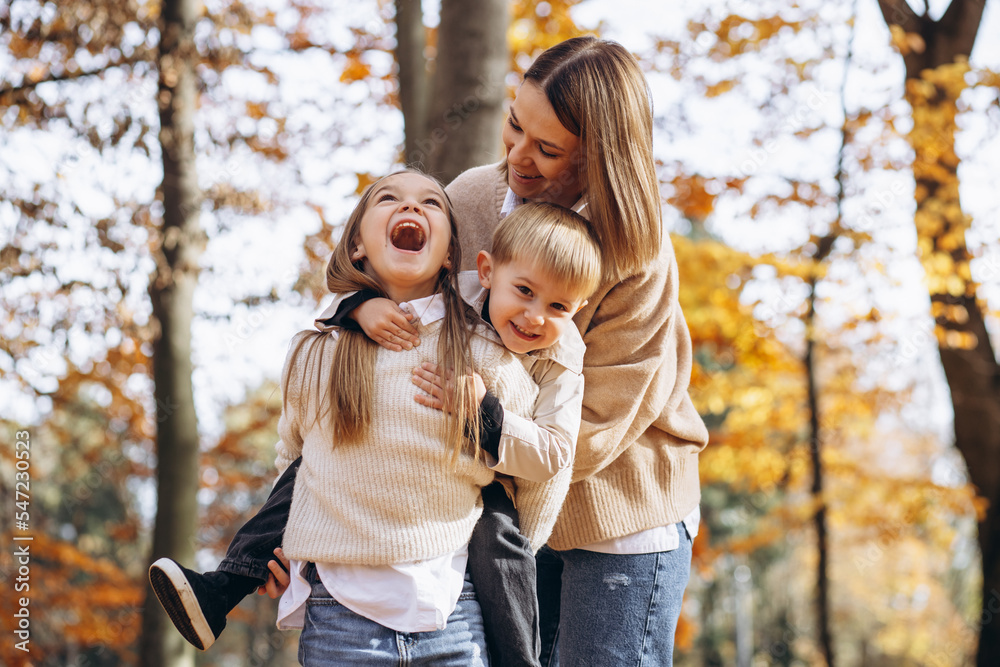 Mother with children having fun in autumn park Mother with children having fun in autumn park