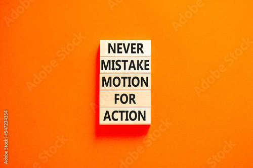 Mistake or action symbol. Concept words Never mistake motion for action on wooden blocks. Beautiful orange table orange background. Business mistake or action concept. Copy space.