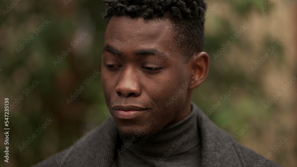 Handsome young black man standing outdoors thinking Handsome young black man standing outdoors thinking