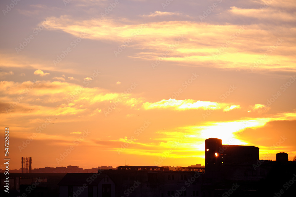 Silhouette of a broken forgotten factory on the background of sunset or sunrise Silhouette of a broken forgotten factory on the background of sunset or sunrise