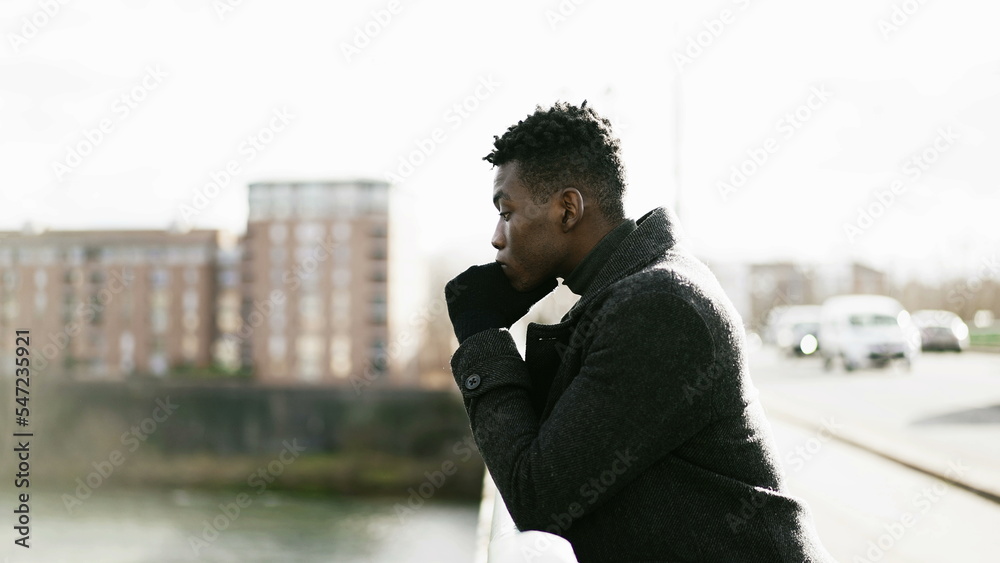 Elegant Contemplative African man looking at horizon wearing winter clothes Elegant Contemplative African man looking at horizon wearing winter clothes