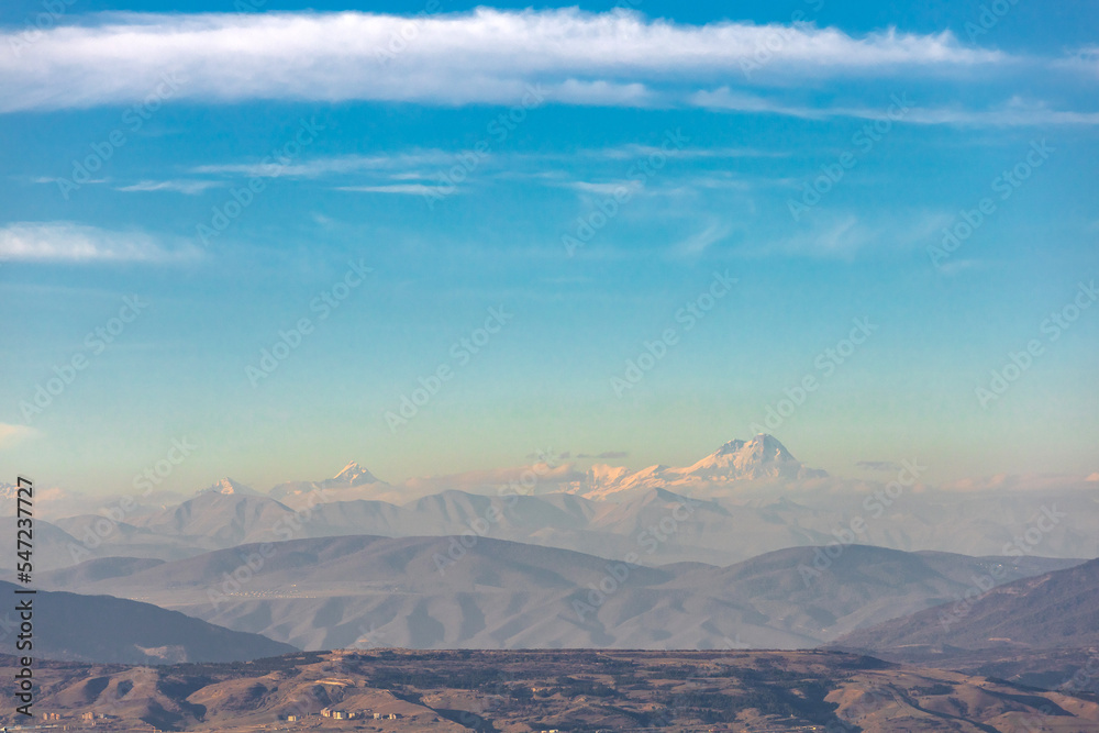 peak of Mount Kazbek among other mountains