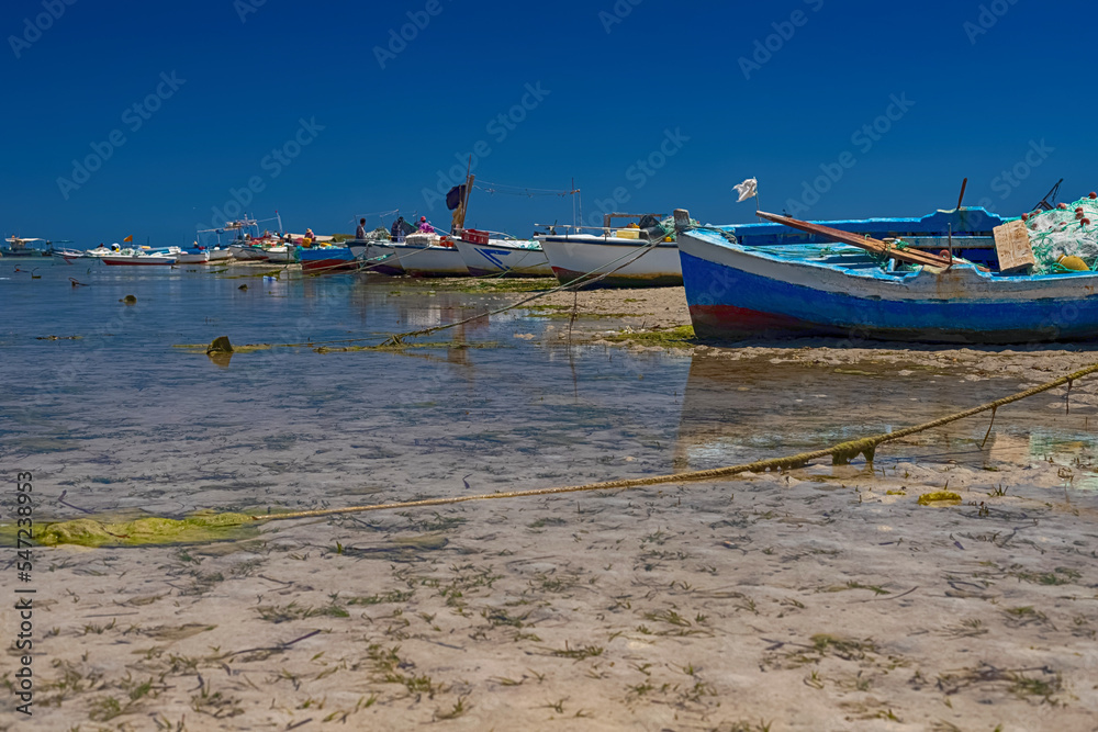 Beautiful view of the boat in the bay of the Mediterranean Sea at low tide on the island of Djerba, Tunisia Beautiful view of the boat in the bay of the Mediterranean Sea at low tide on the island of Djerba, Tunisia