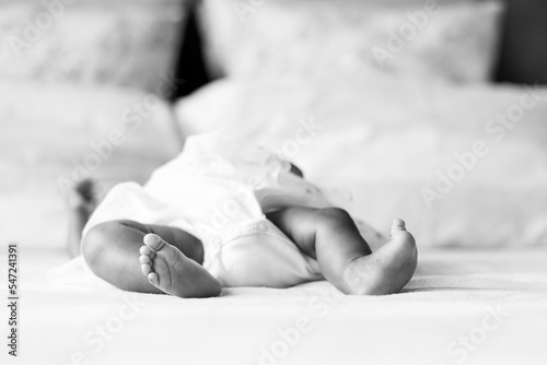 A close up of a content and peaceful newborn baby's bare feet