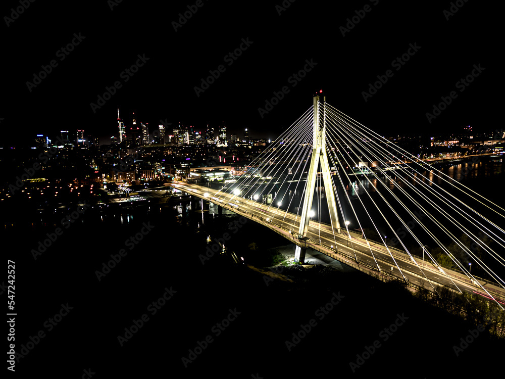 The Swietokrzyski Bridge over Vistula river, on modern cable-stayed bridge in Warsaw, Downtown. Aerial night view
