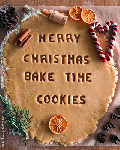 Making cookie words Merry Christmas, Bake Time, cookies. Christmas Bake Time text cutted on shortcrust dough, baking Christmas cookies.