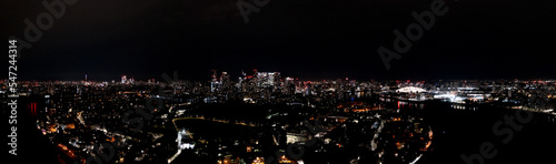Beautiful cityscape of modern urban London metropolis at night, with lightened skyscrapers, towers, and buildings, aerial panorama view.