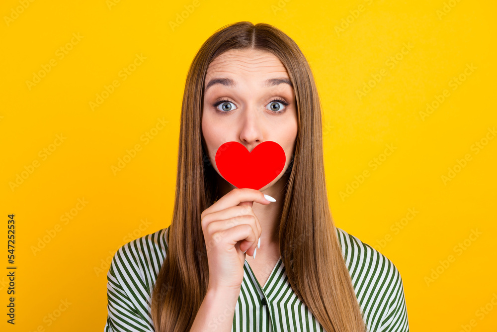 Photo of charming woman cover mouth small red paper heart isolated vivid color background Photo of charming woman cover mouth small red paper heart isolated vivid color background