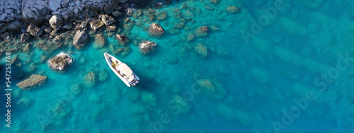 Aerial drone top down photo of inflatable speed boat anchored in tropical exotic island