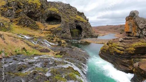 Waterfalls and rock formations in Gjáin valley, Iceland, with crystal clear wild river and lush vegetation.  photo