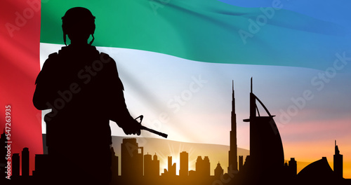 Silhouette of a solider saluting on background of sunrise and Dubai skyline. UAE national holidays, National Day, Commemoration Day concept