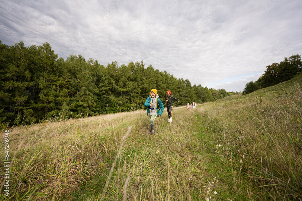 Brothers having fun and run outdoor near forest.