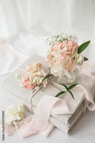 Small Bouquet of Pink Hydrangea on Stack of Linen Covered Books