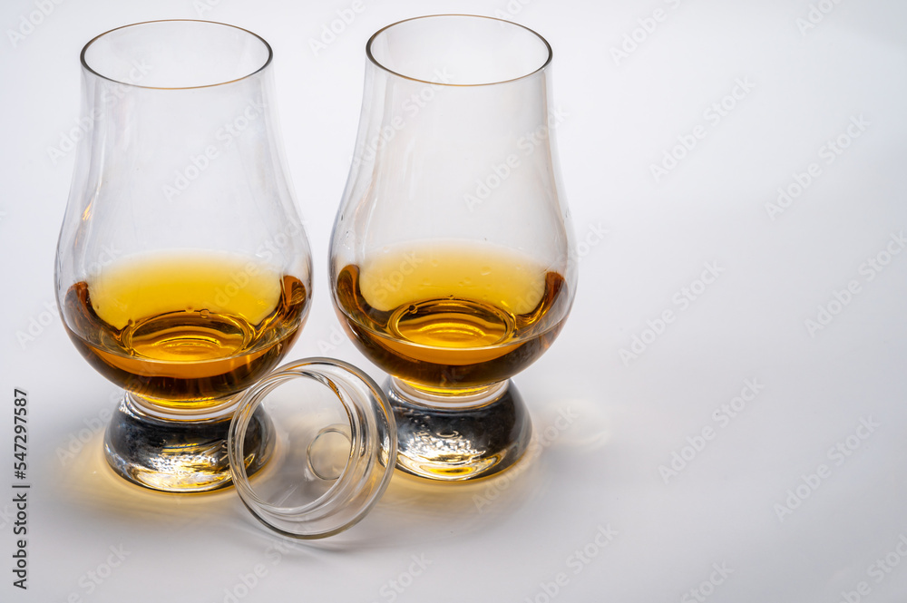 Tulip-shaped tasting glasses with dram of Scotch single malt or blended whisky on white background Tulip-shaped tasting glasses with dram of Scotch single malt or blended whisky on white background