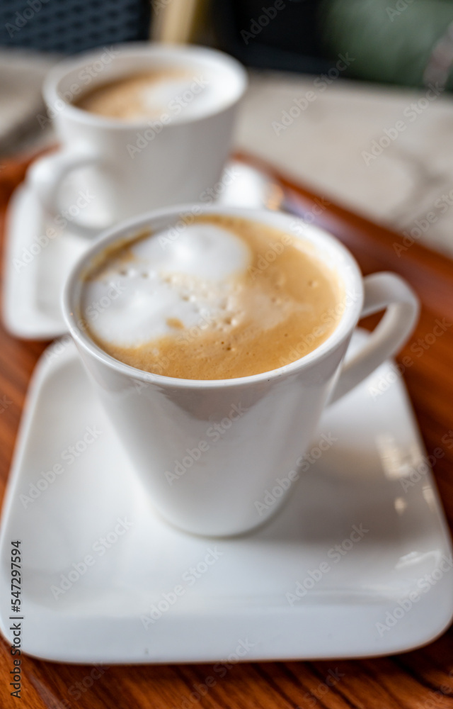 White cup of coffee latte served in outdoor cafe in France White cup of coffee latte served in outdoor cafe in France