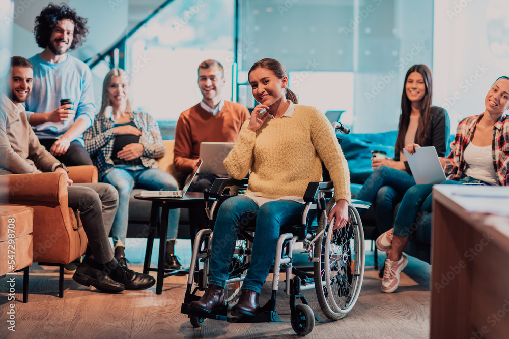 Businesswoman in wheelchair having business meeting with team at modern office. A group of young freelancers agree on new online business projects Businesswoman in wheelchair having business meeting with team at modern office. A group of young freelancers agree on new online business projects