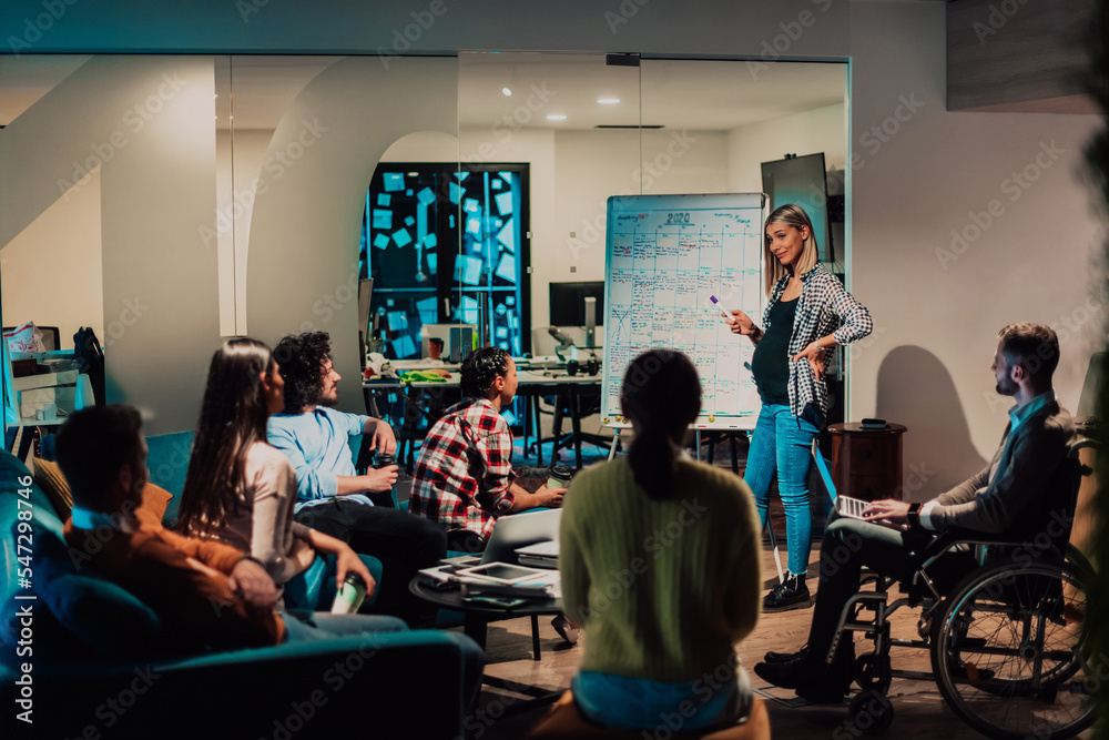 A pregnant businesswoman leads a creative meeting of a diverse business team in a modern coworking A pregnant businesswoman leads a creative meeting of a diverse business team in a modern coworking