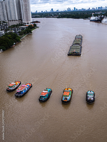 grop of boat tug towing a barge in Chaopraya river, Bankok, Thailand