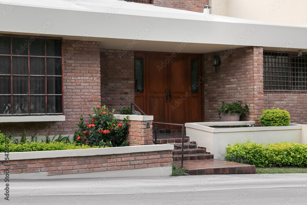 Obraz premium Entrance of beautiful residential building with wooden door on sunny day